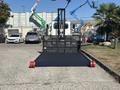2020 Peterbilt 330 with a flatbed equipped with a lifting mechanism and red rollers positioned in a parking area