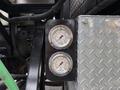 Two pressure gauges mounted on a metal panel indicating charge and high pressure for a 2016 Peterbilt 348