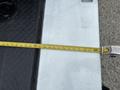 A 2013 Ford F-250 SD with a measuring tape laid across its bed showing measurements along a metallic surface