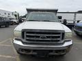 A 2004 Ford F-350 SD pickup truck with a flatbed and visible wear on the front grille and bumper