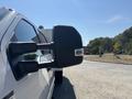 A 2019 Ford F-550 prominently features its side mirror with dual extensions designed for towing and enhanced visibility