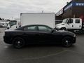 A black 2017 Dodge Charger is parked with its side profile visible showcasing a sleek design and dark wheels