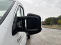 A close-up of the side mirror on a 2023 RAM Promaster 3500 showing its black housing and reflective surface