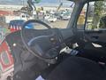 The interior of a 2022 Freightliner M2 106 featuring a steering wheel dashboard with controls and a driver's seat