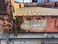A rusted metal platform with a chain and a label displaying the SkyJack logo and information about the 2010 SJ model