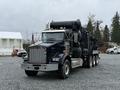 A 2018 Kenworth T800 truck with a dark blue exterior features a large black tank system mounted on the back and a chrome grille with angular headlights