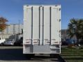 A 2011 Freightliner M2 106 truck with a white cargo box and multiple vertical securing rods at the rear