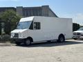 A 2012 Ford Econoline box truck with a white exterior parked on a street