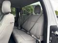 Interior of a 2018 Ford F-150 showing the back seat with gray fabric upholstery and seat belts visible