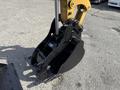 Close-up of a black hydraulic excavator bucket attached to a yellow arm of a 2022 Caterpillar 306 machine