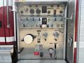 A 1999 Freightliner FL80 fire truck's control panel featuring various gauges switches and levers for operation