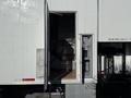 A 2011 Freightliner M2 106 truck with an open door revealing an empty cargo area and a control panel next to it