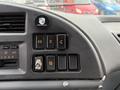 Dashboard controls of a 2007 GMC F7500 featuring buttons for air conditioning and various functions including a toggle switch