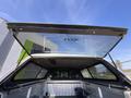 A 2014 Ford F-150 with an open camper shell revealing the truck bed and a clear glass top