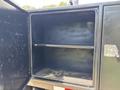 The image shows an open storage compartment of a 2013 RAM 2500 with two shelves and no visible items inside