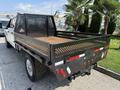 A 2020 Ford F-350 SD truck with a flatbed featuring a metal frame and wooden surface at the rear