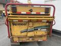 A yellow Vermeer Corporation BC1000XL wood chipper with a red protective guard and visible branding on the rear side