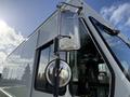 A 2017 Freightliner MT45 with a clear side mirror and a cylindrical light mounted on the driver's side