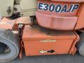 A 2009 JLG E300AJP aerial lift with large wheels and an orange body featuring identifying decals and safety labels