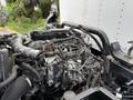 Detail of the engine compartment of a 2018 Hino 195 featuring various hoses wires and components including a visible turbocharger and fuel injection system