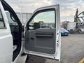 A 2014 Ford F-550 truck with an open driver side door showing a gray interior and handle