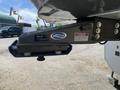 A 2021 Grand Design Recreational ST3478MBS featuring a sturdy hitch attachment with safety labels and a blue securing mechanism