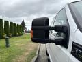 A white 2013 Ford F-250 SD with a extended side mirror clearly visible in the foreground