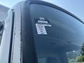 A close-up view of the window of a 2012 Hino 338 displaying a certification sticker with months of the year listed on it