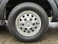 Close-up of a wheel and tire of a 2023 Ford Transit with a silver alloy rim and a rugged winter tire designed for improved traction