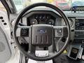 Steering wheel of a 2019 Ford F-750 featuring buttons on the left control panel and a dashboard with gauges and a radio display behind the wheel