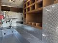 Interior view of a 2008 International 4400 with metal shelving units and storage compartments along the wall and a flat metal floor area