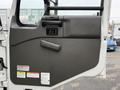 The image shows the interior door panel of a 2009 UD Trucks UD 3300 featuring a gray armrest and window controls with warning labels attached