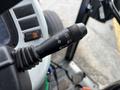 A close-up view of the control lever from a 2009 New Holland T4020 tractor featuring symbols for lights and direction indicators