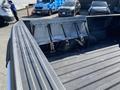A 2018 Ford F-150 with a snow plow attachment mounted in the truck bed featuring several straps securing it in place