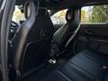 Interior view of a 2023 Fisker Ocean showcasing black leather rear seats with a sleek modern design and ample legroom
