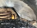 Close-up of the undercarriage of a 2006 Ford Econoline showing suspension components and a tire tread