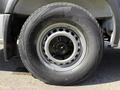 A close-up of a tire mounted on a silver wheel of a 2016 Mercedes-Benz Sprinter showcasing a black tire with textured tread and identifying markings on the sidewall