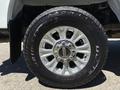 A close-up of a silver alloy wheel on a 2020 Ford F-350 SD featuring a Bridgestone tire with visible tread pattern and the manufacturer's logo on the center hub