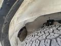 Close-up of the wheel arch and tire of a 2022 GMC Savana highlighting the textured surface of the tire and the surrounding vehicle body