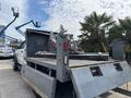 A white 2016 RAM 5500 truck with a flatbed featuring mounted equipment and tools on the rear