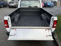 A 2011 Ford Ranger with an open tailgate exposing the truck bed featuring a flat surface and side walls
