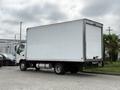 A 2018 Hino 195 box truck with a white cargo box and black chassis is parked on a concrete surface