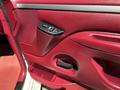 Interior door panel of a 1995 Ford F-250 featuring red upholstery and controls for windows and locks