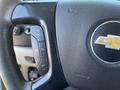 Close-up of a steering wheel from a 2013 Chevrolet Silverado 1500 featuring control buttons for cruise control and a Chevrolet logo