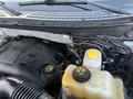 Engine compartment of a 2014 Ford F-150 featuring a V6 engine coolant reservoir and various engine components