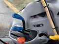 A close-up view of the control panel of a 2009 New Holland T4020 with colored levers in blue orange and yellow for operating various functions