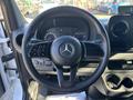 The interior of a 2021 Mercedes-Benz Sprinter 2500 featuring a steering wheel with the Mercedes logo and various controls on the left side