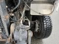 Close-up of the front axle and tire of a 2012 Workhorse W62 showing the mechanical components and tread pattern of the tire