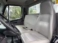 Interior of a 2013 Freightliner 114SD featuring a gray driver's seat and a spacious passenger seat with seatbelt