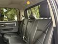 Interior view of a 2018 RAM 1500 showing the back seat with black leather upholstery and seat belts attached